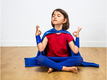 child wearing cape meditating