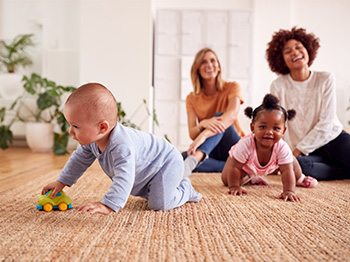 babies playing on the floor with parents looking on
