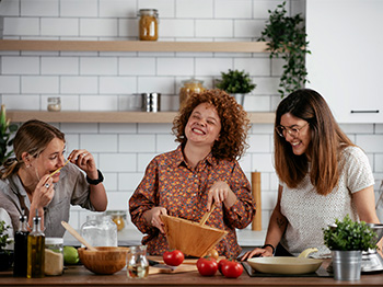 Three women cooking together in a kitchen
