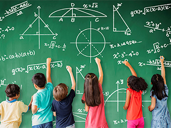 Six school age kids at chalk board drawing math equations.