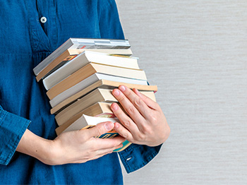 holding  a stack of books