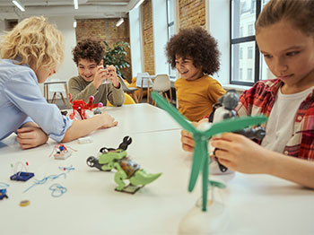 Adult and kids making sculptures at a table