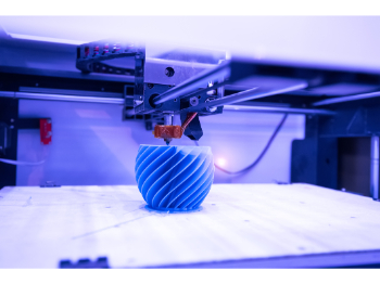 3D printer creating  blue cup with swirls.