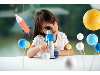 curious child looking in microscope