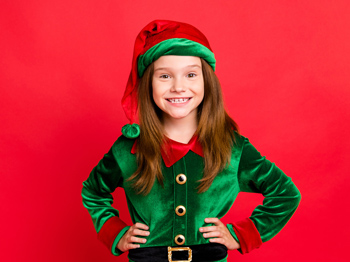A child elf stands with hands on hips in a velvety button-down green outfit.