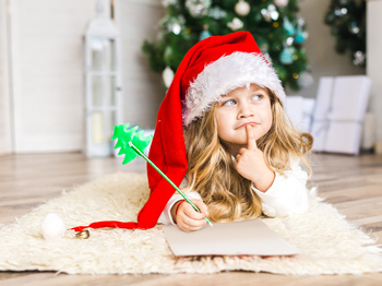 A child lying on the floor with a Santa Clause hat wir