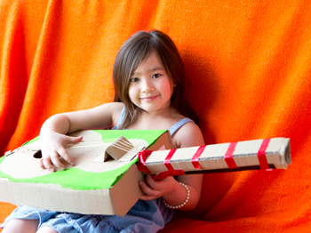 A child holding a homemade guitar.