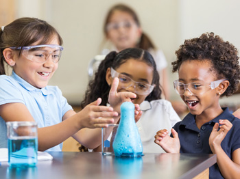 Children smiling at a messy science experiment.