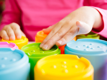 A child playing with colourful tactile toys.