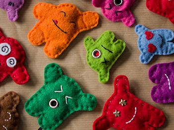 Many colourful felt plushie mini monsters.