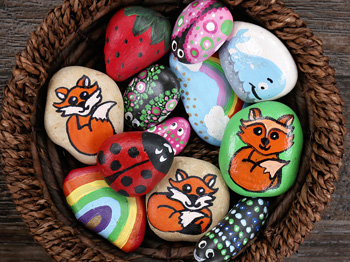 A collection of painted rocks in a wicker basket.