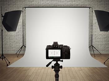 Camera in front of white backdrop with lighting