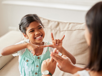A child learning how to count in sign language with a parent.