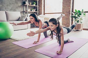 Mother and daughter on exercising on yoga mat