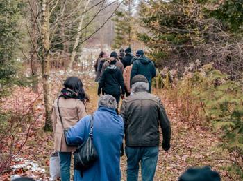 A photograph of people walking along a trail in nature. 